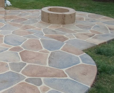 One of a kind stamped patio with a concrete fire place in the middle in Lansing, Michigan.