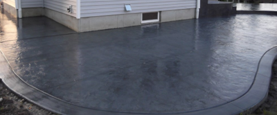 Dark gray stamped concrete along side of home in Lansing, Michigan.