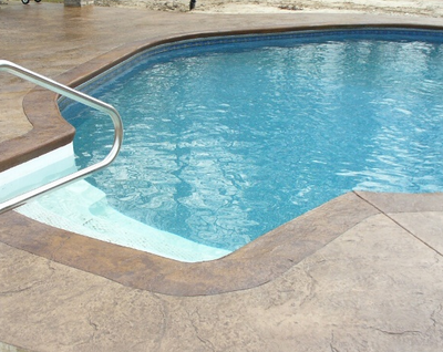 Pool in Lansing, Michigan with steps and concrete stamped deck.
