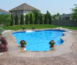 Outdoor pool in Mason, Michigan with stamped concrete and landscaped backyard.