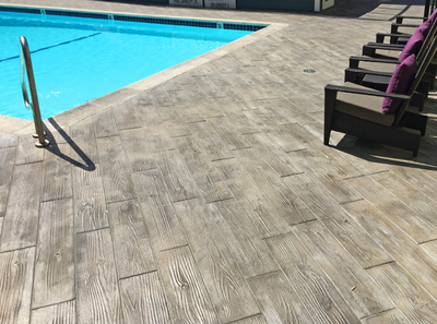 Pool Deck with lounge chairs and stamped wood grain deck.